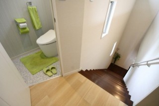 人が集まる家＿２階のトイレは、台形の省スペースに。１階とメリハリをつけたデザインに